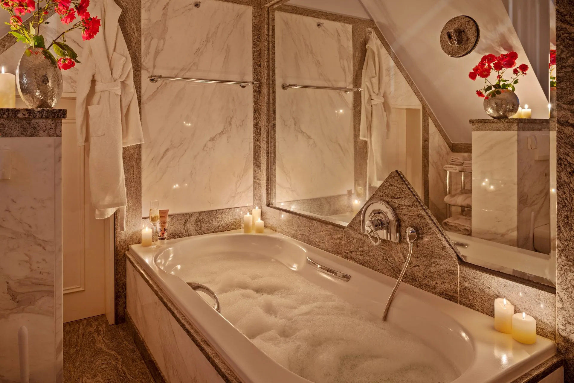 Marmorbad mit eingelassener Wanne, Schaumbad und brennenden Kerzen