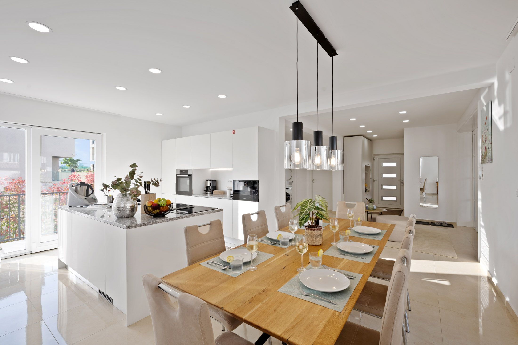 Open kitchen with a dining table set with wine glasses