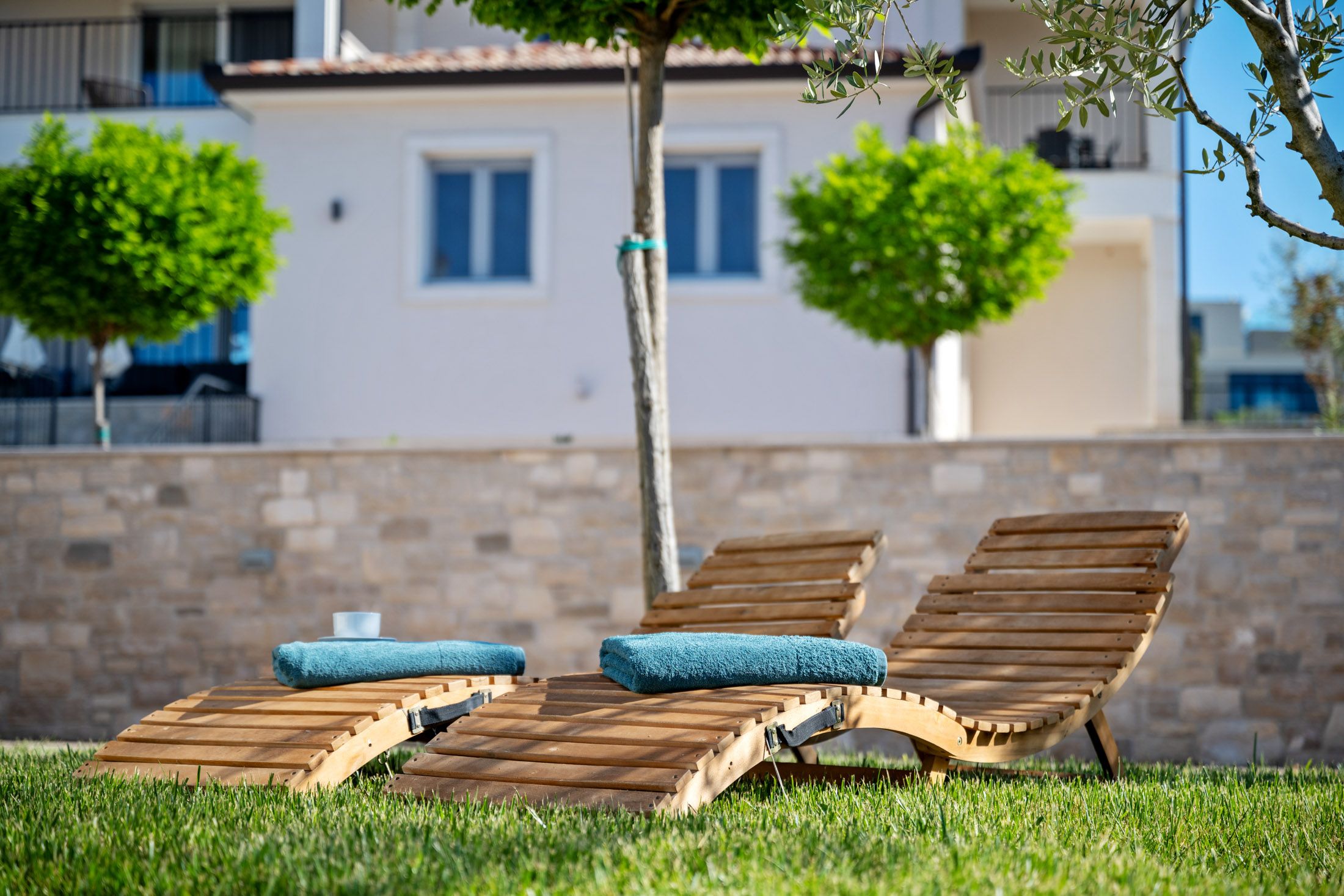 Wooden loungers with rolled towels in the garden