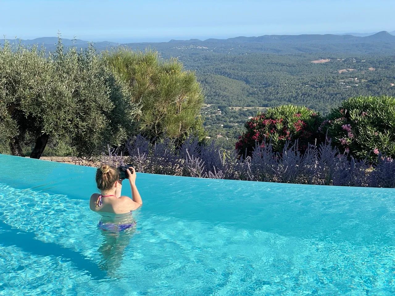 Immobilienfotografie für Ferienwohnungen Fotograf in Action - Ivy Stenzel steht im Pool mit der Kamera