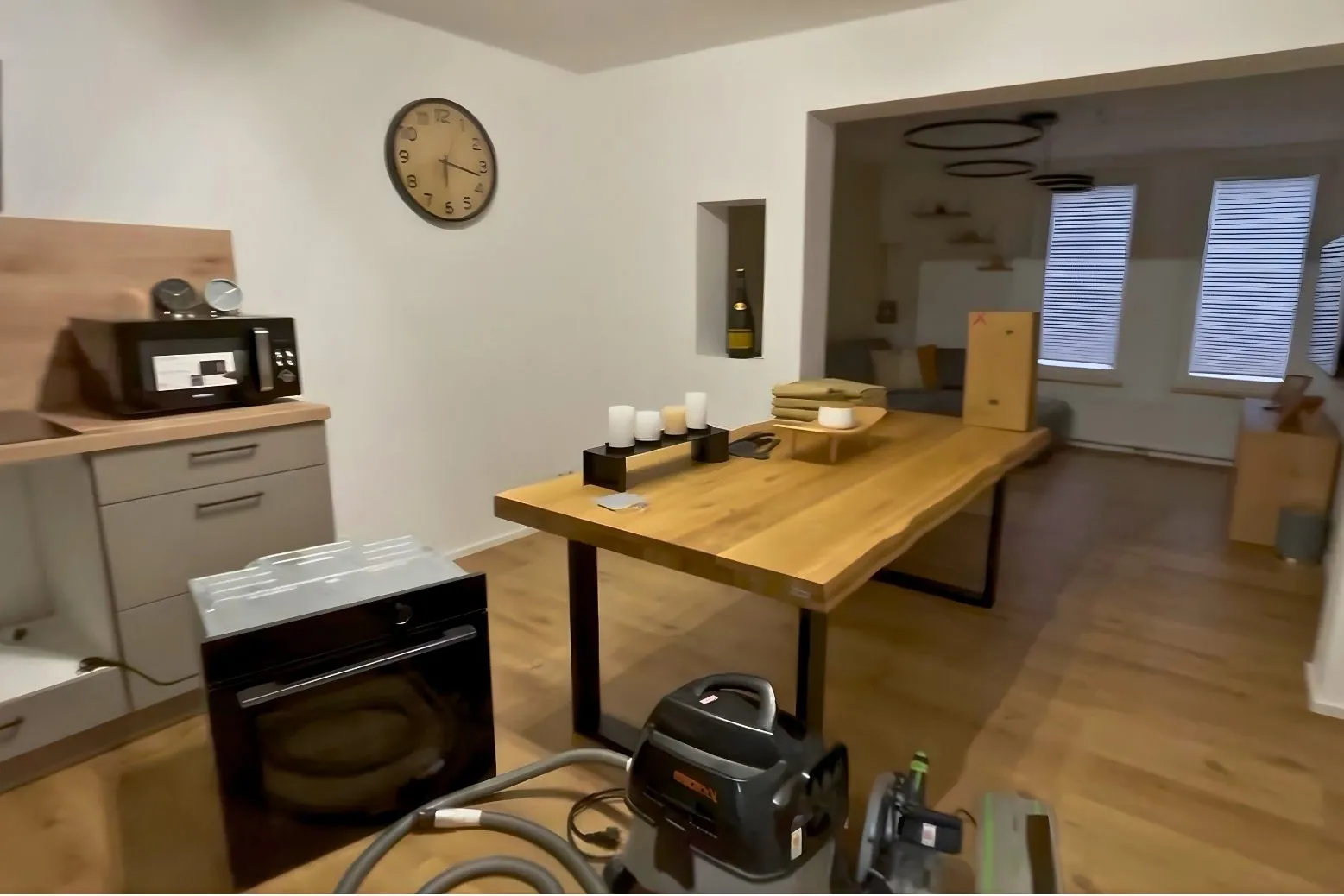 Kitchen and dining area mid-renovation with cleaning equipment and tools