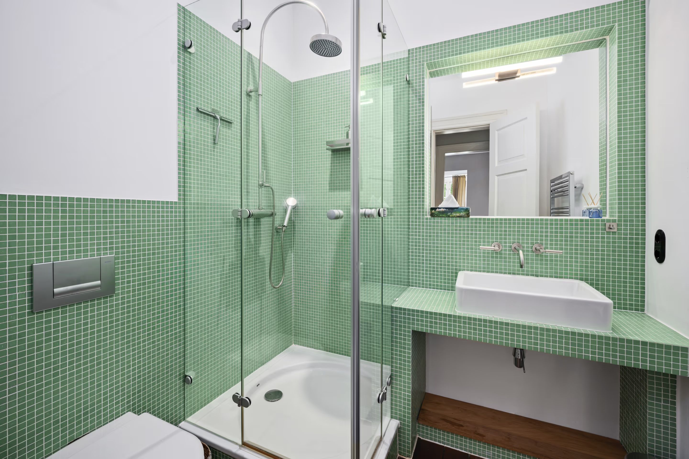 Bathroom with green mosaic tiling and a walk-in shower