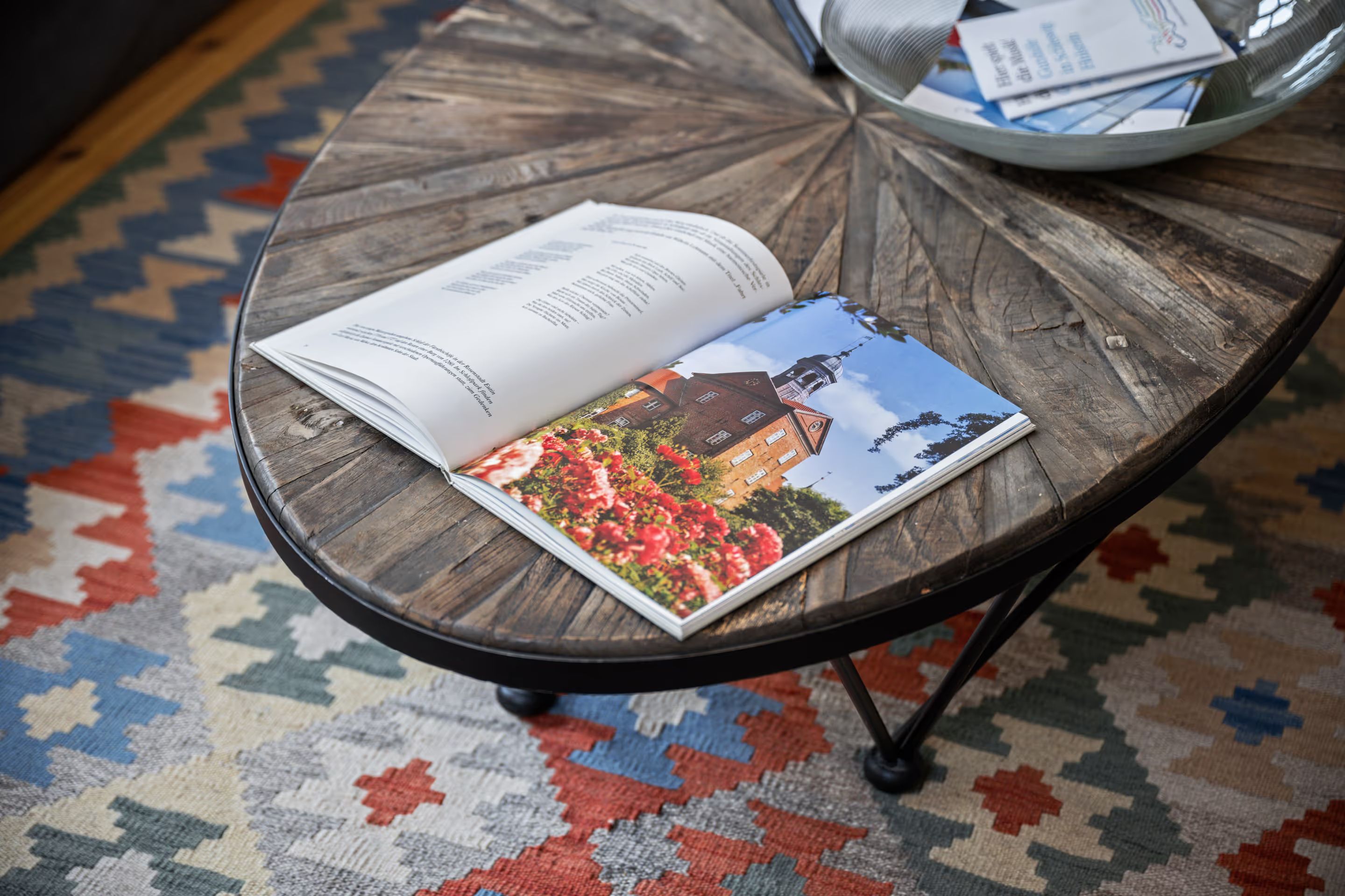 Round wooden table with an open magazine