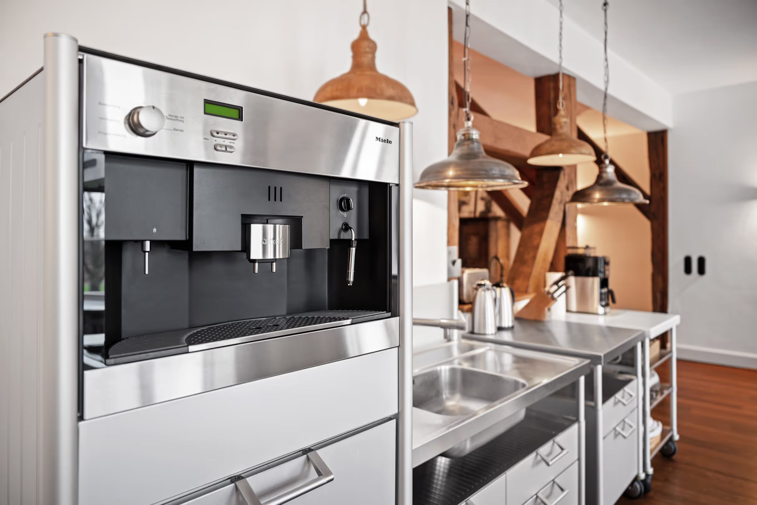 Kitchen with a built-in coffee machine and exposed beams