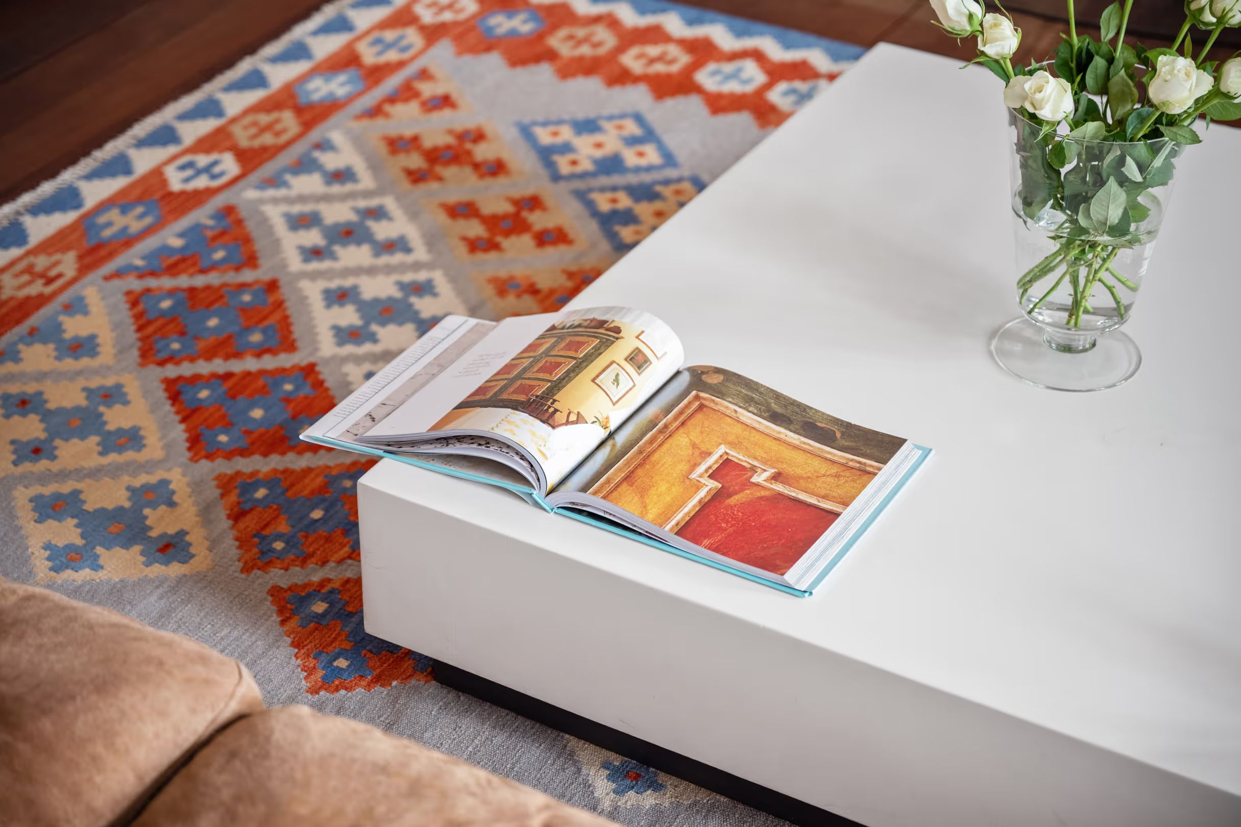 Coffee table detail with a magazine and a bouquet of flowers