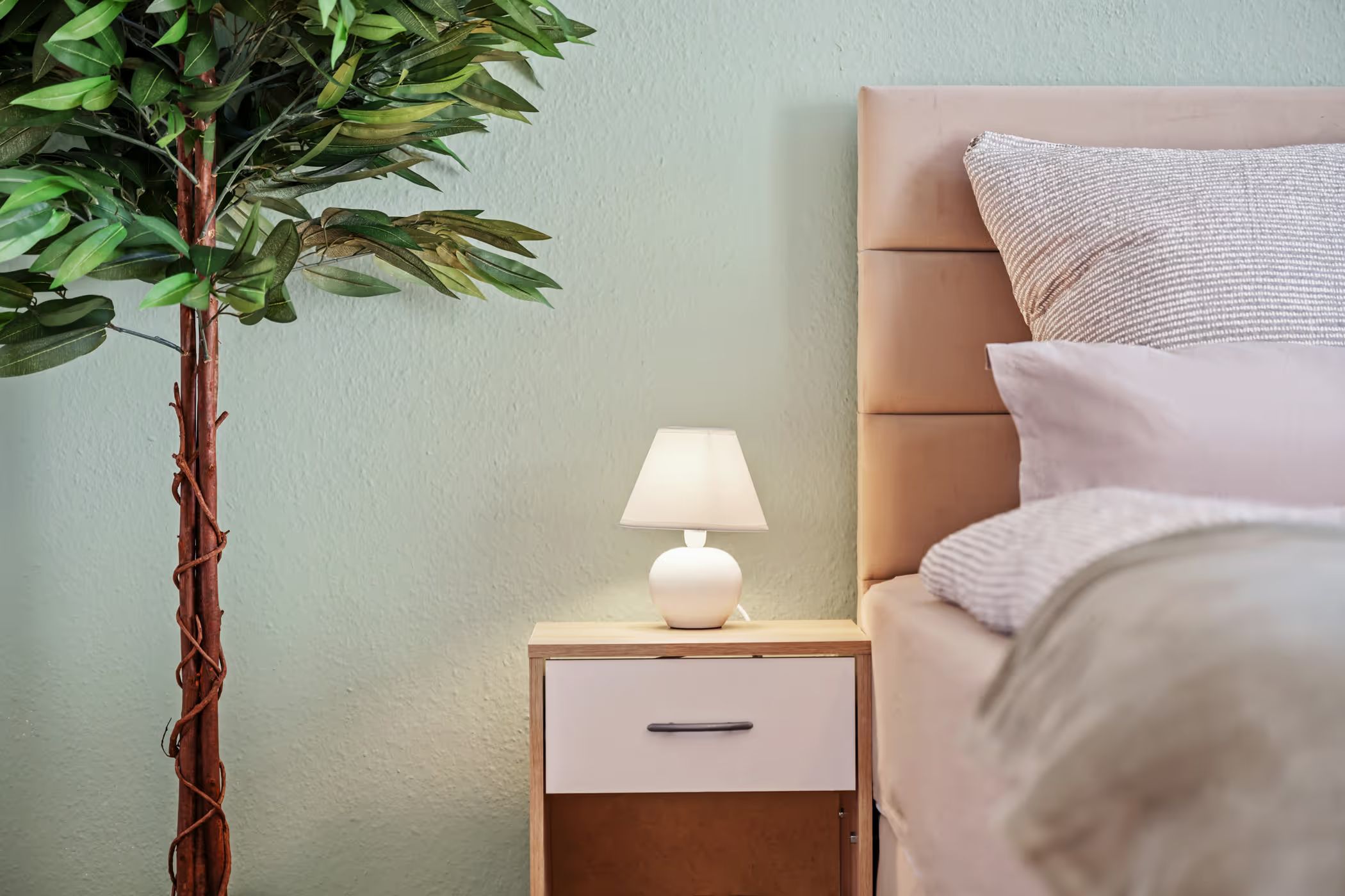 Nightstand with lamp beside the bed