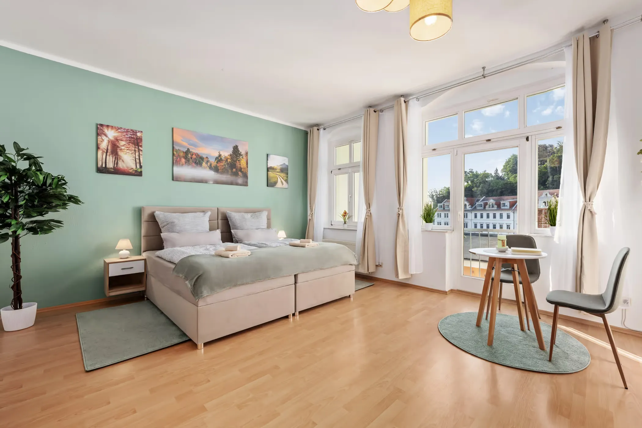 Bedroom with double bed, art prints and a large window in a holiday home in Meissen