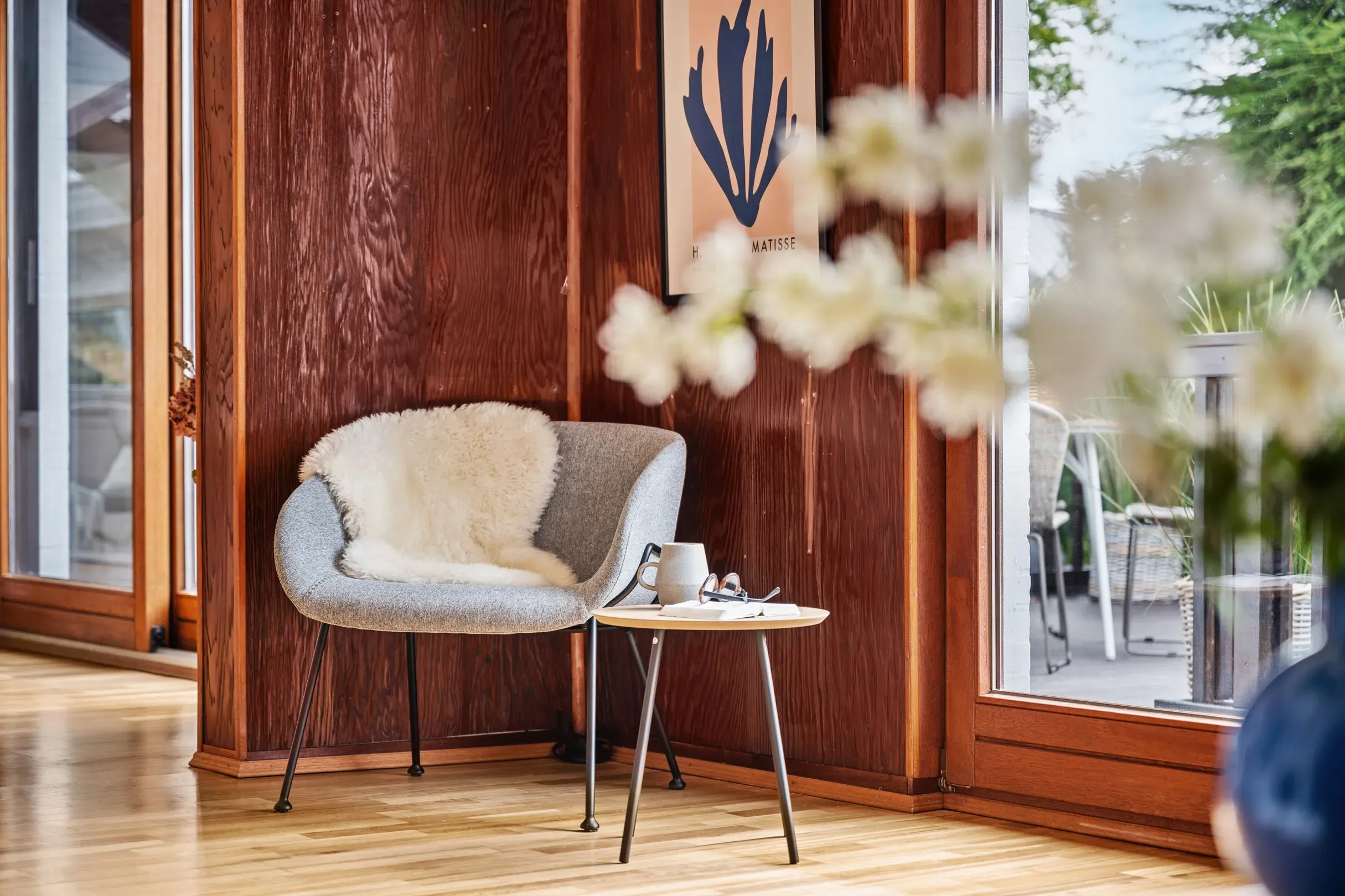 Gemütliche Leseecke mit Sessel, Fellauflage und Beistelltisch in einer Ferienwohnung in Hamburg