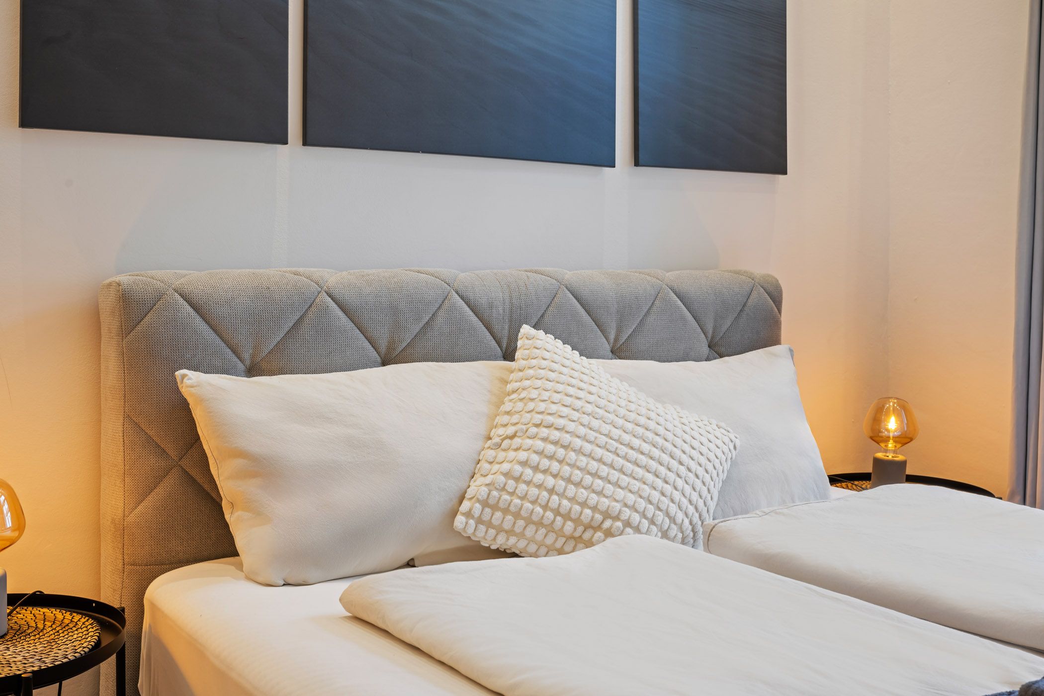 Bed with pillows and atmospheric wall art