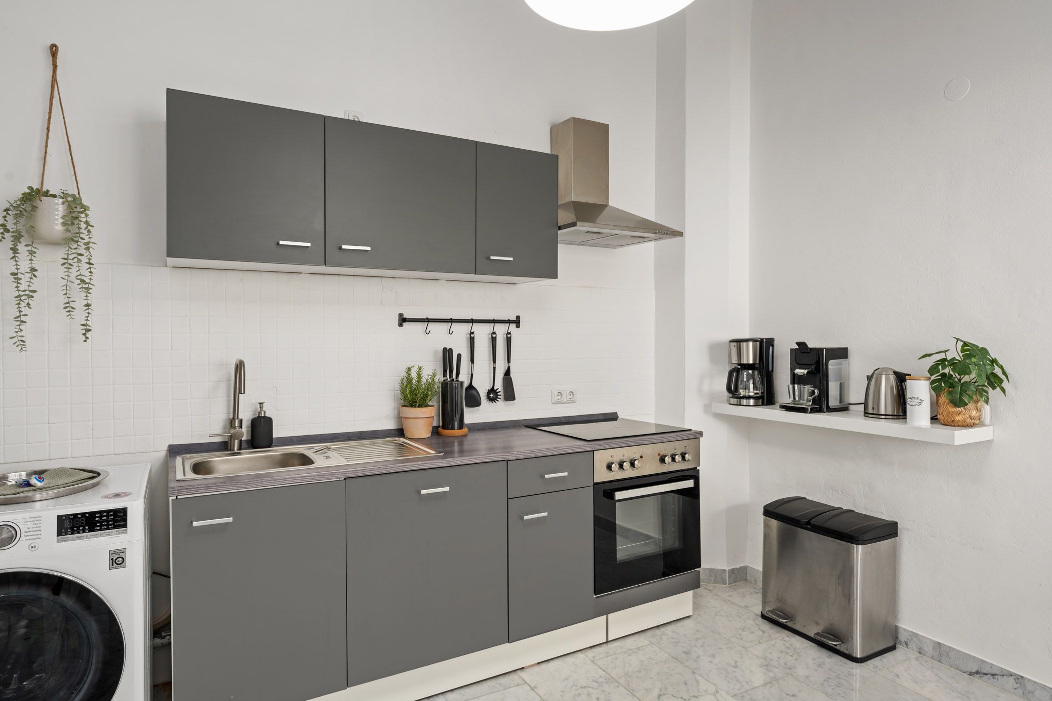 Open kitchen with gray cabinet fronts and a washing machine
