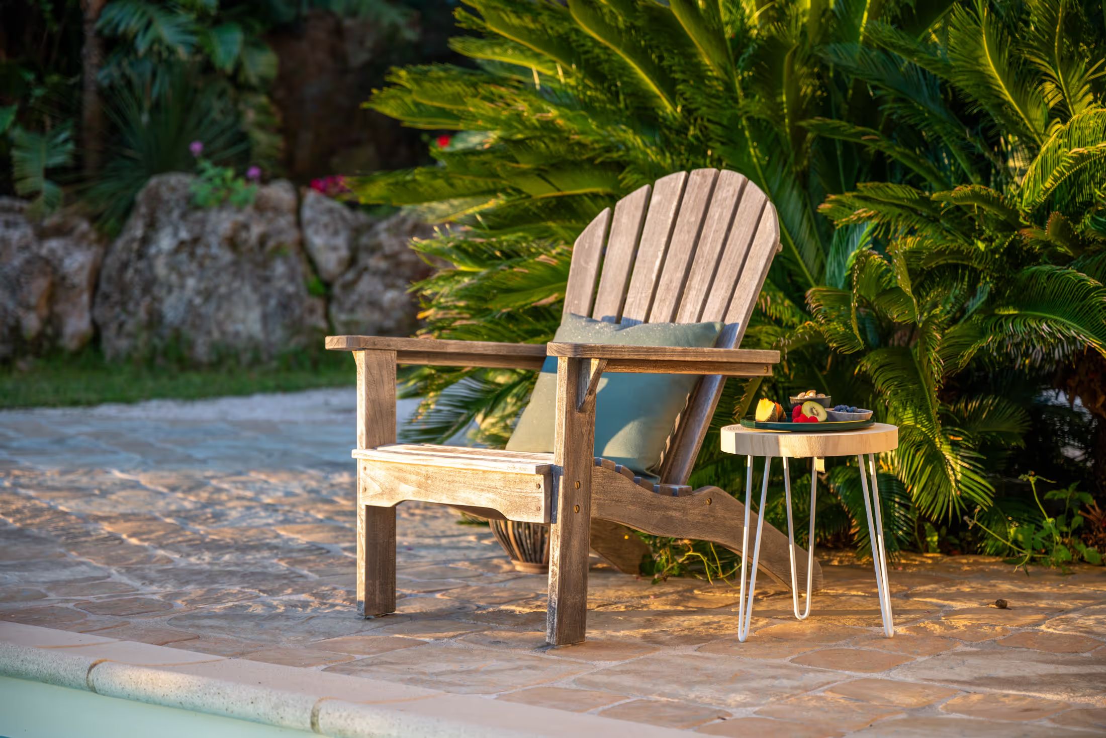 Lounge chair by the pool with a plate of fruit