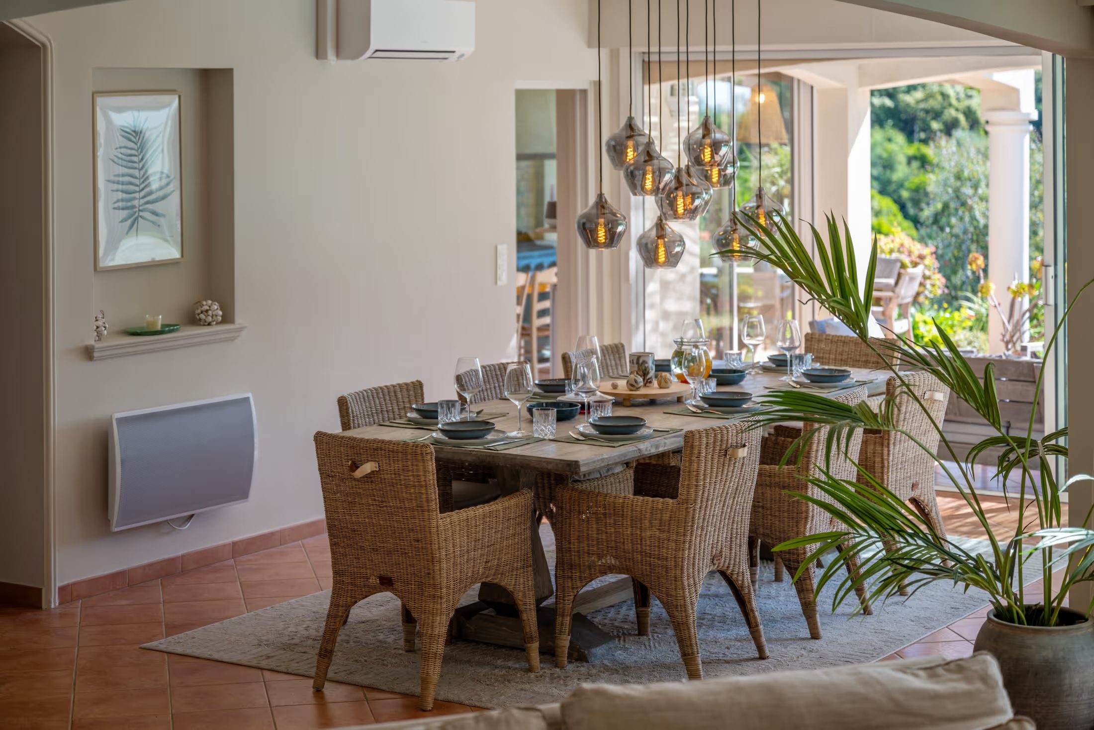 Dining area with rattan chairs and pendant lights