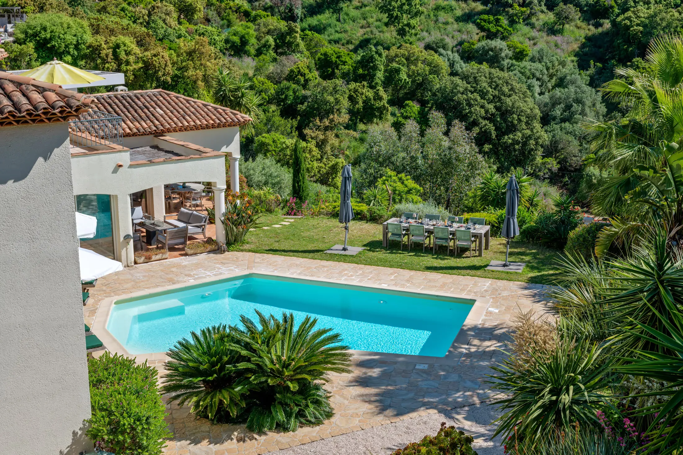 View from above of the pool, terrace, and garden