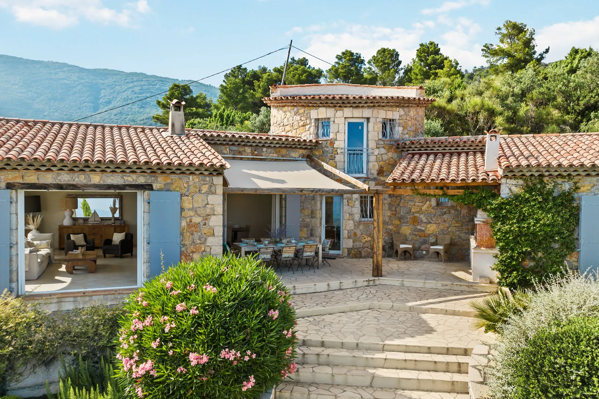 Außenansicht der Villa La Genestière in Frankreich mit blauen Fensterläden und blühendem Oleander
