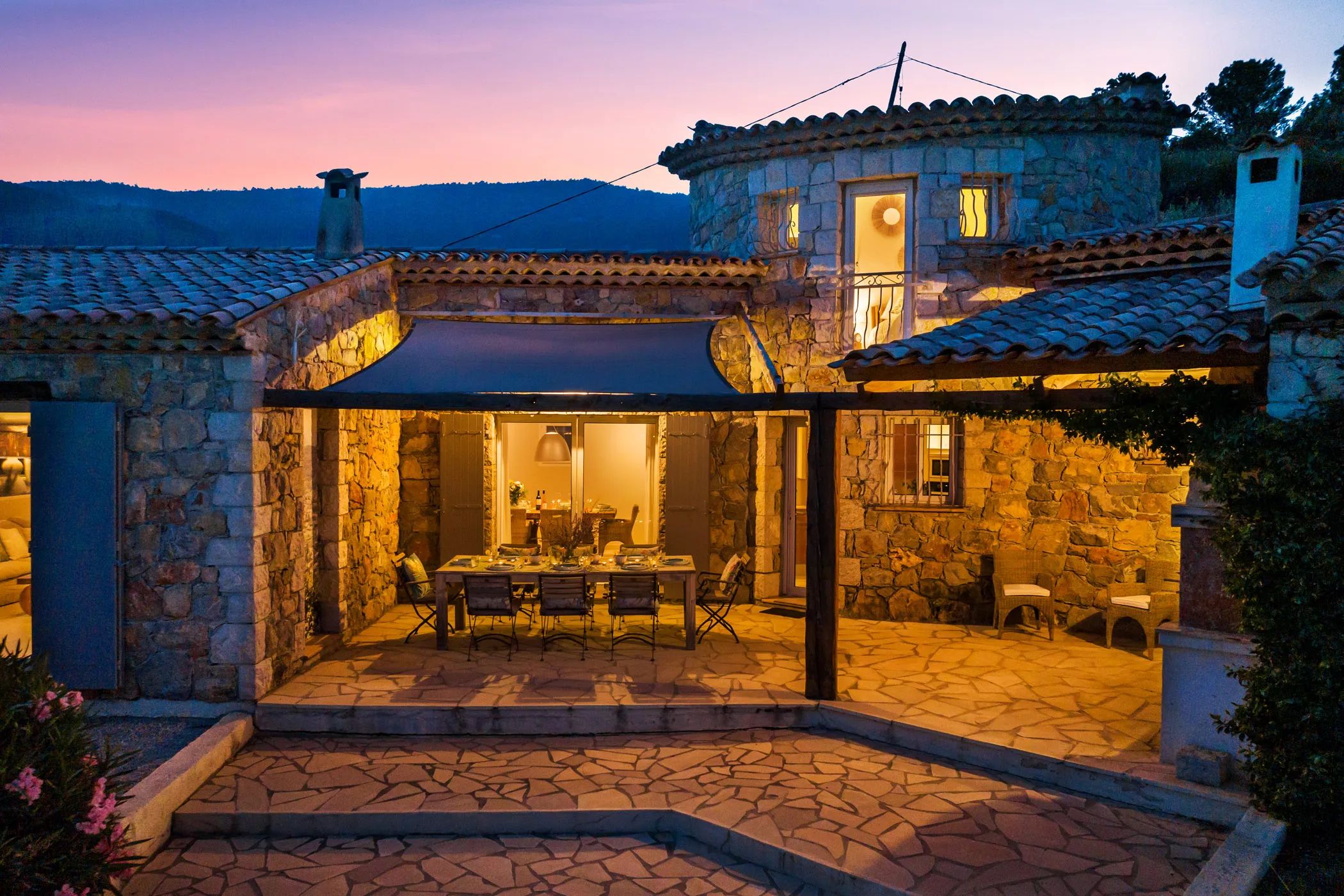 Villa at dusk with an illuminated dining terrace