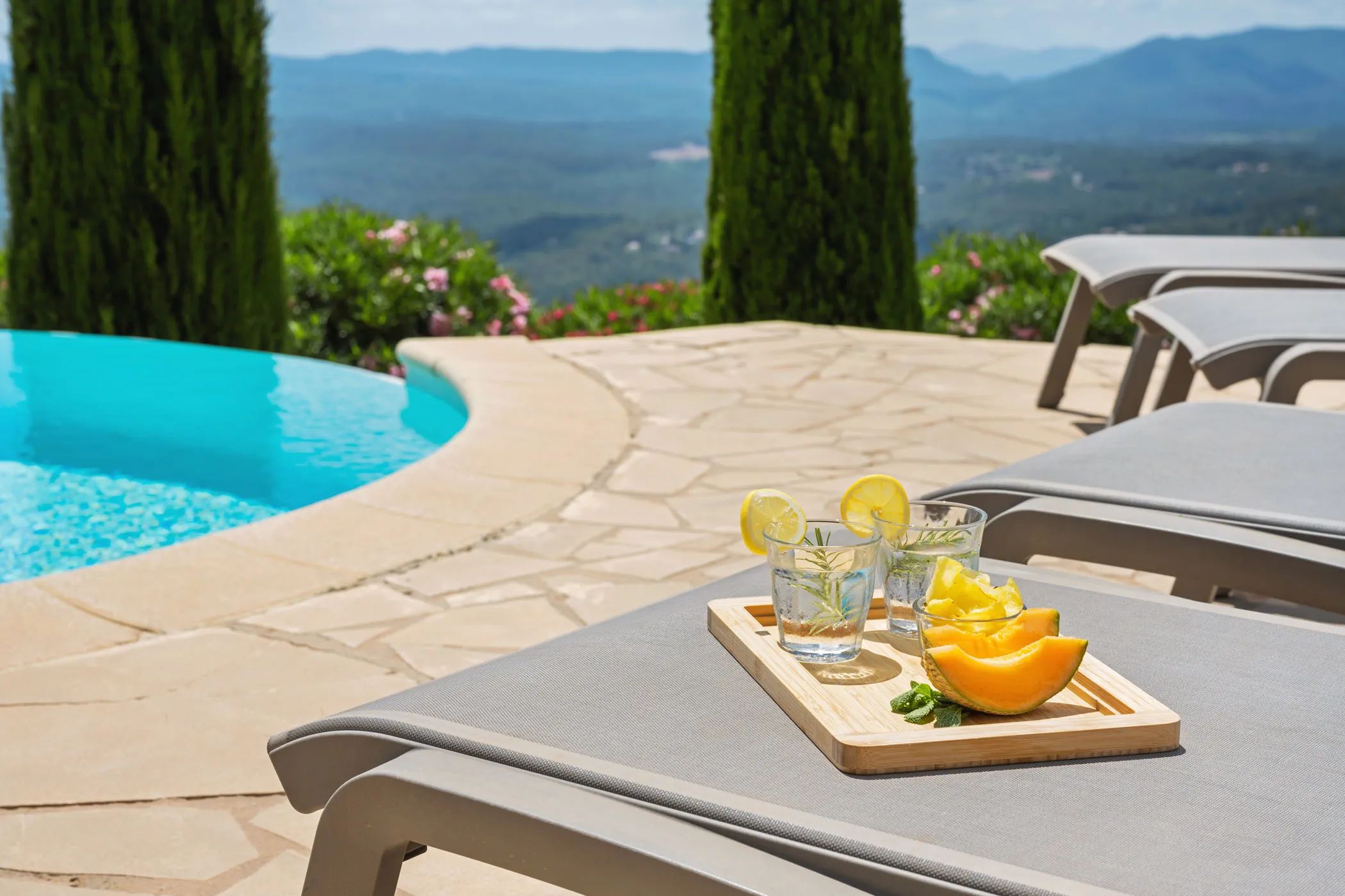 Refreshing drinks and fruit on a lounger by the pool