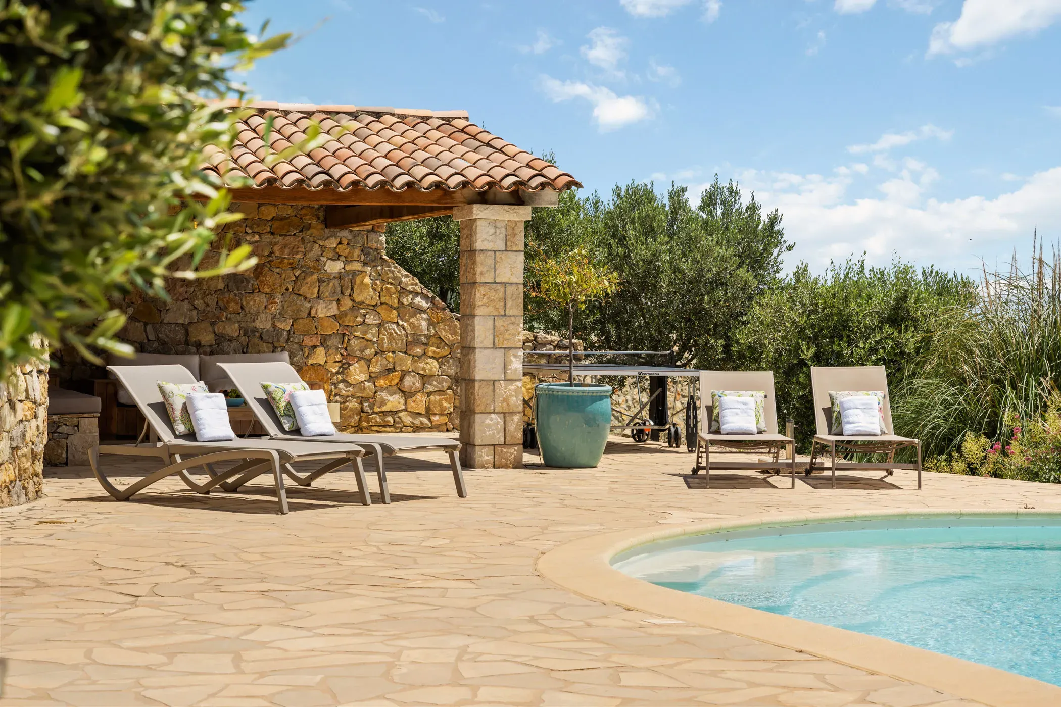 Well-kept pool terrace with loungers at a villa in France photographed by Ivy