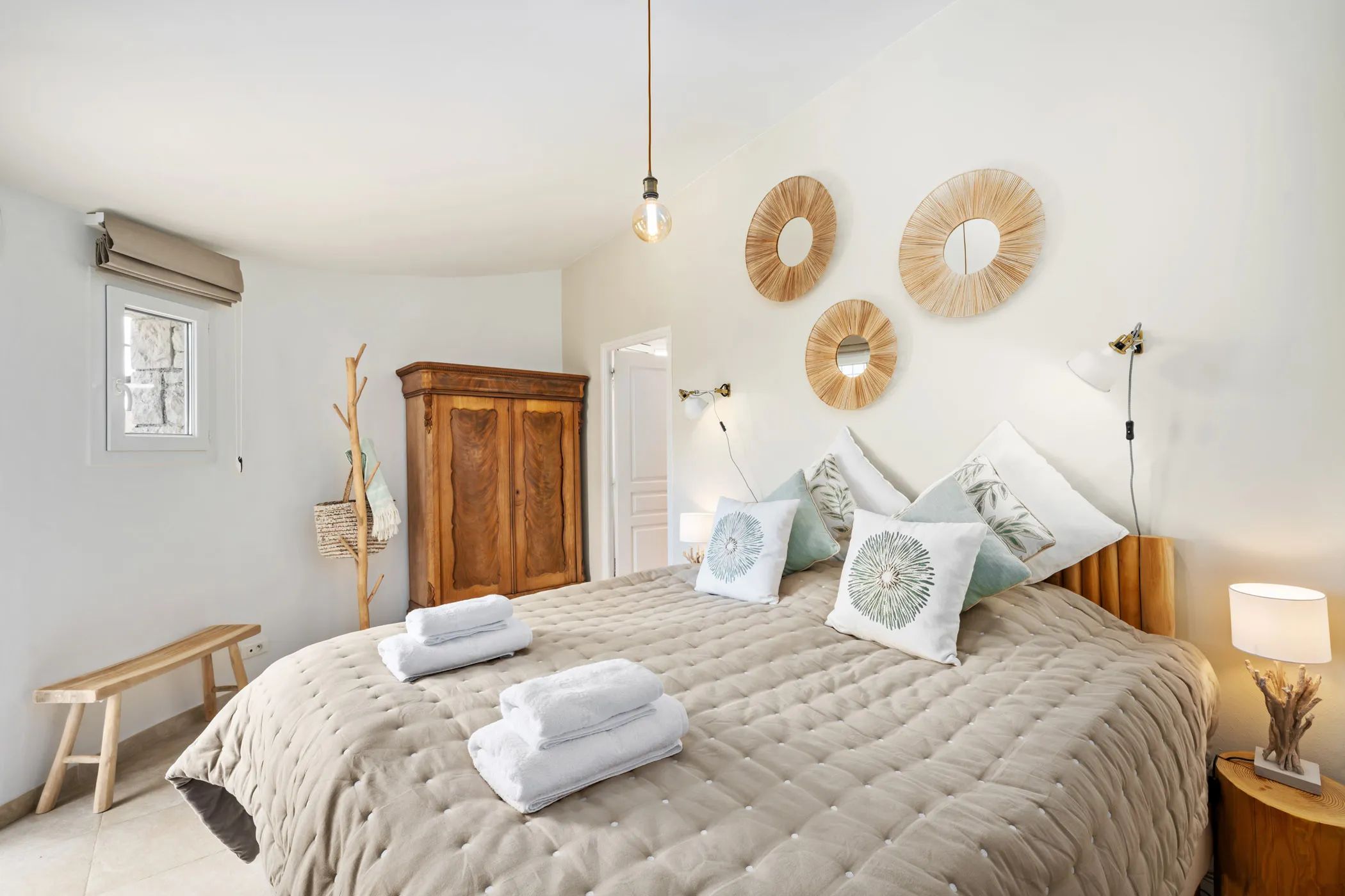 Bedroom with a made bed and wall mirrors