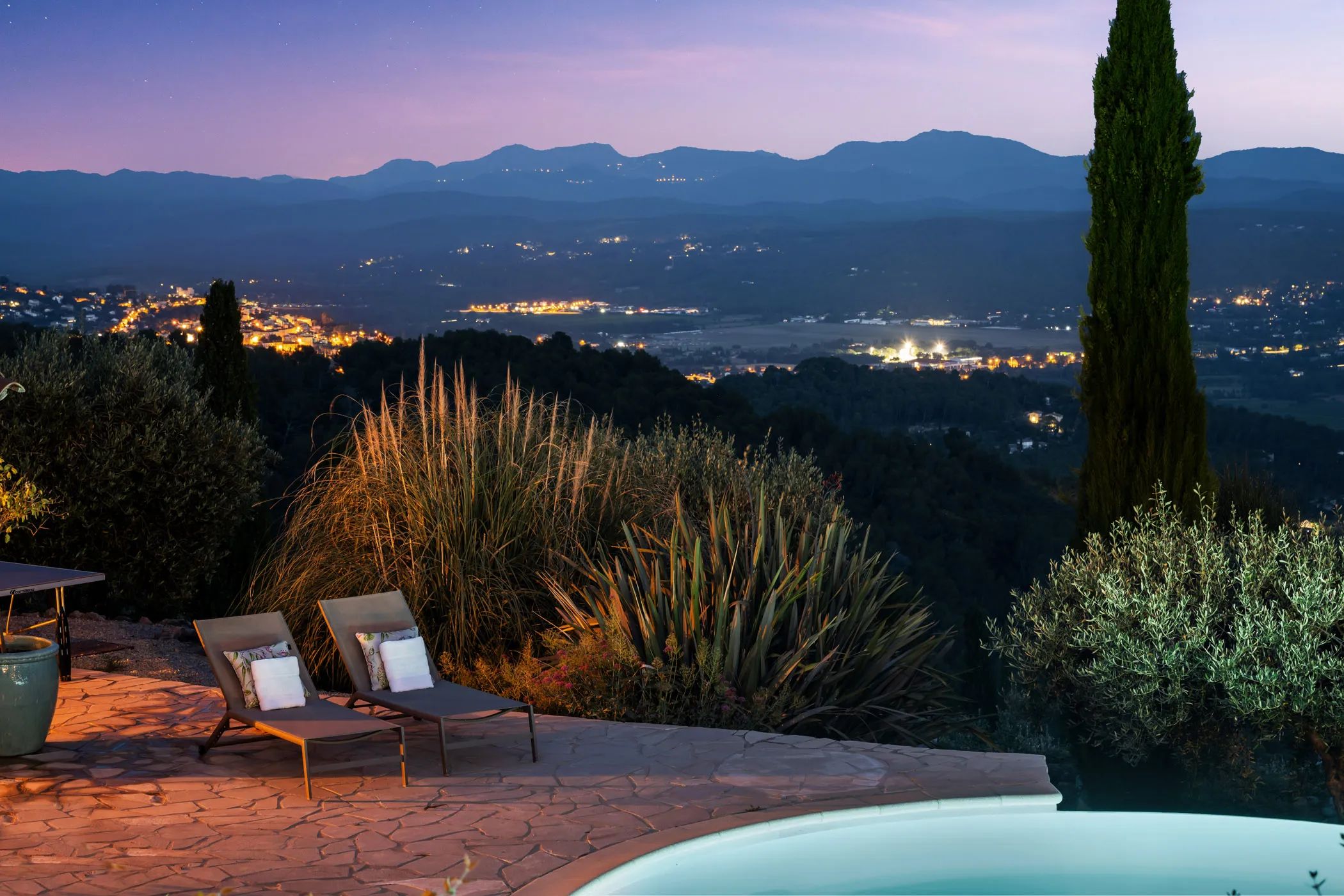 Terrace with loungers and valley view at dusk