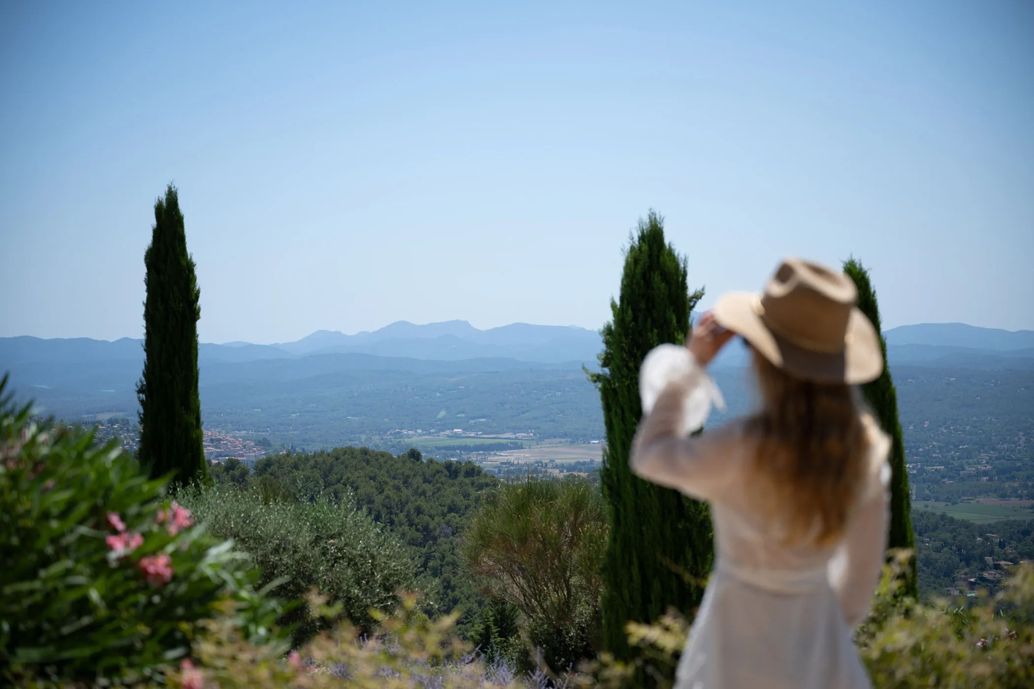 Woman in a hat gazing out over the hilly landscape