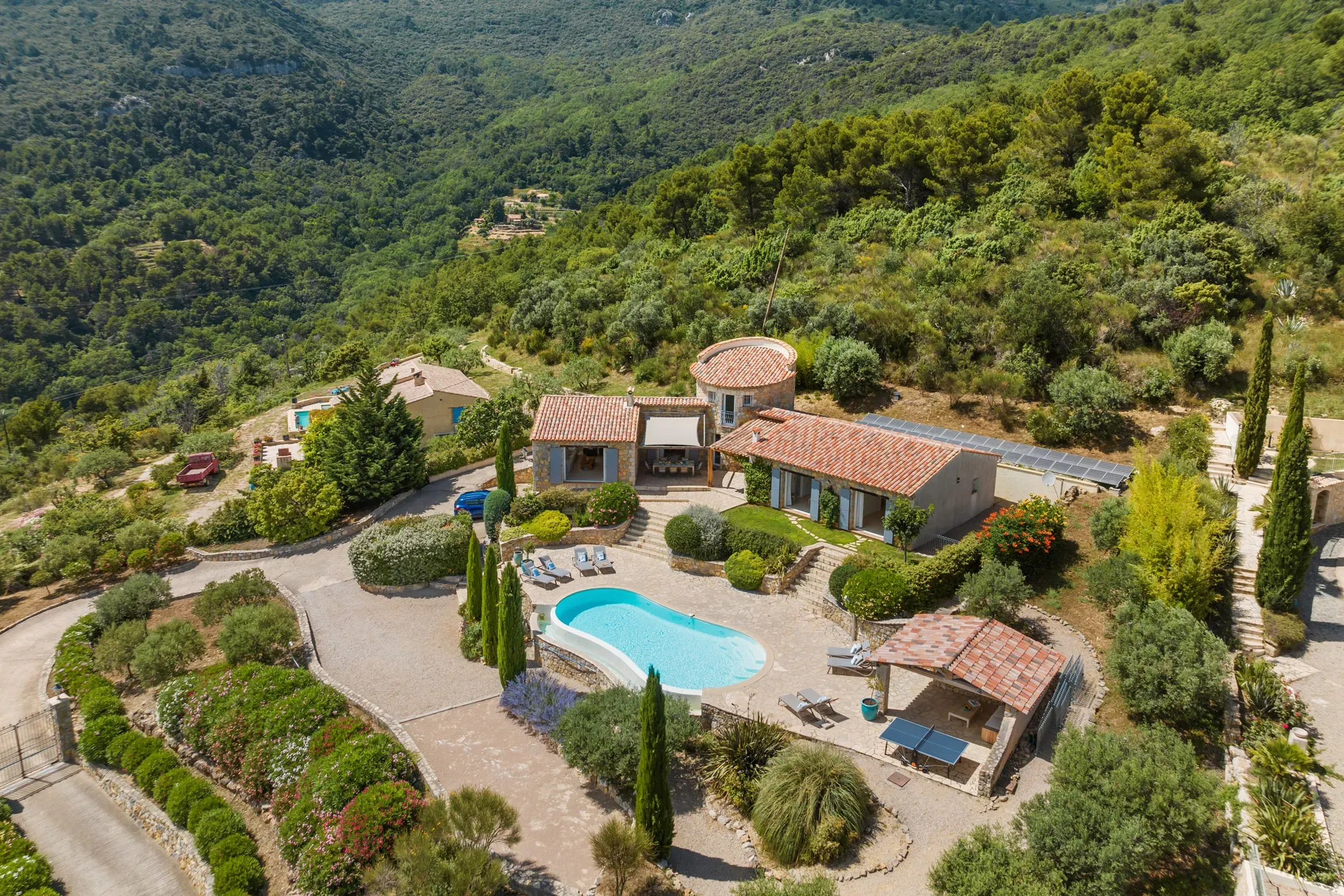 Luftaufnahme der Villa La Genestière in Frankreich mit Pool, Terrasse und Blick über die bewaldeten Hügel der Provence