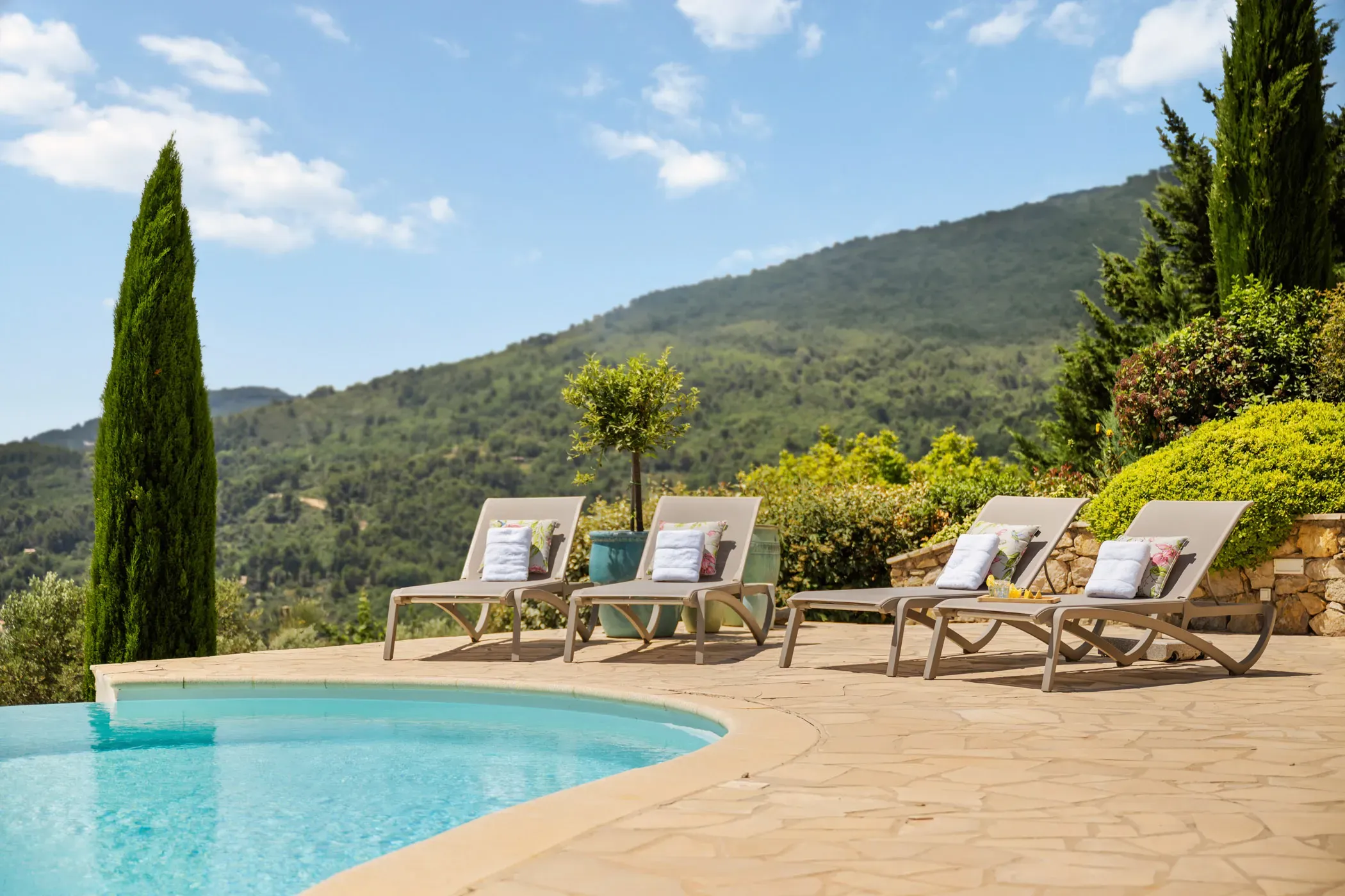 Real estate photography of holiday homes, pool with cozy loungers in France