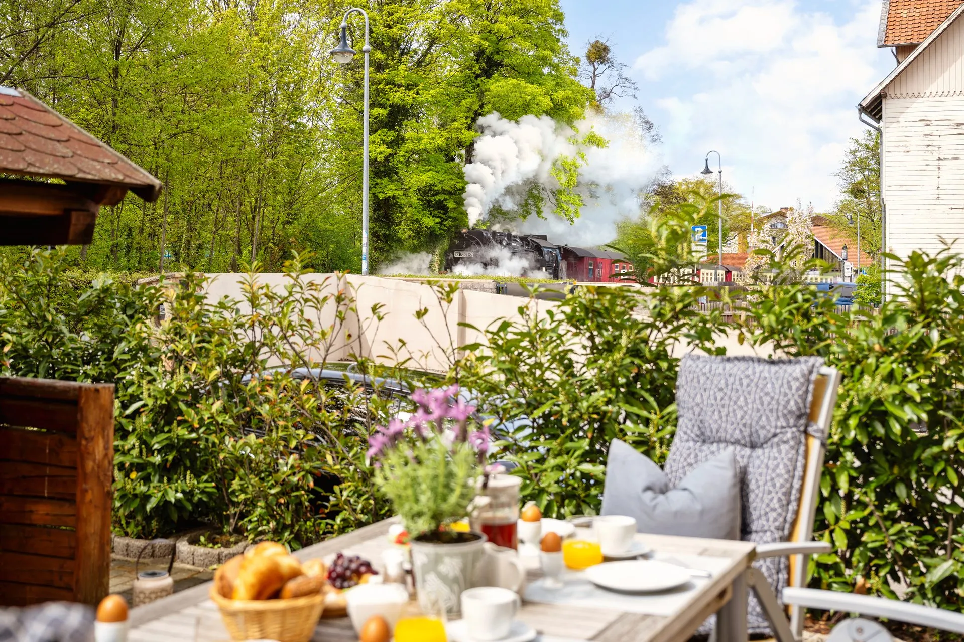 Frühstück auf der Terrasse, dahinter fährt die Dampflok der Harzer Schmalspurbahn vorbei